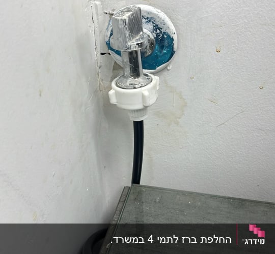 ברז מים עם צינור מחובר לקיר